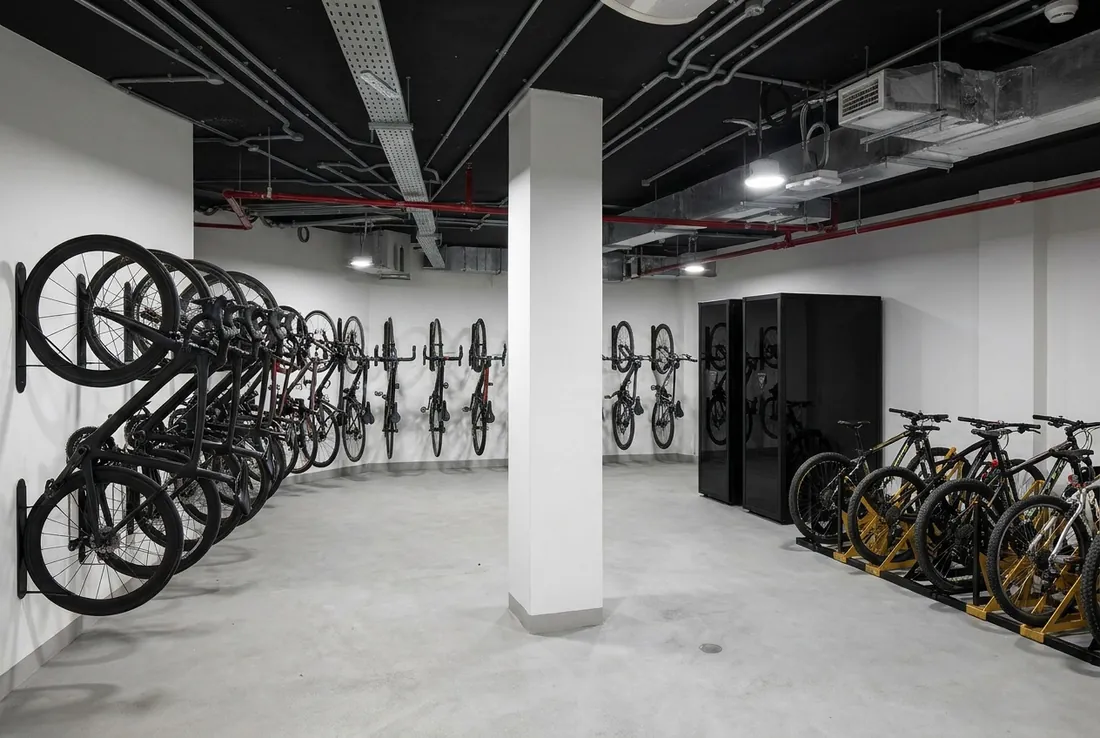 End-of-trip bike room with vertical wall racks, black lockers and floor racks
